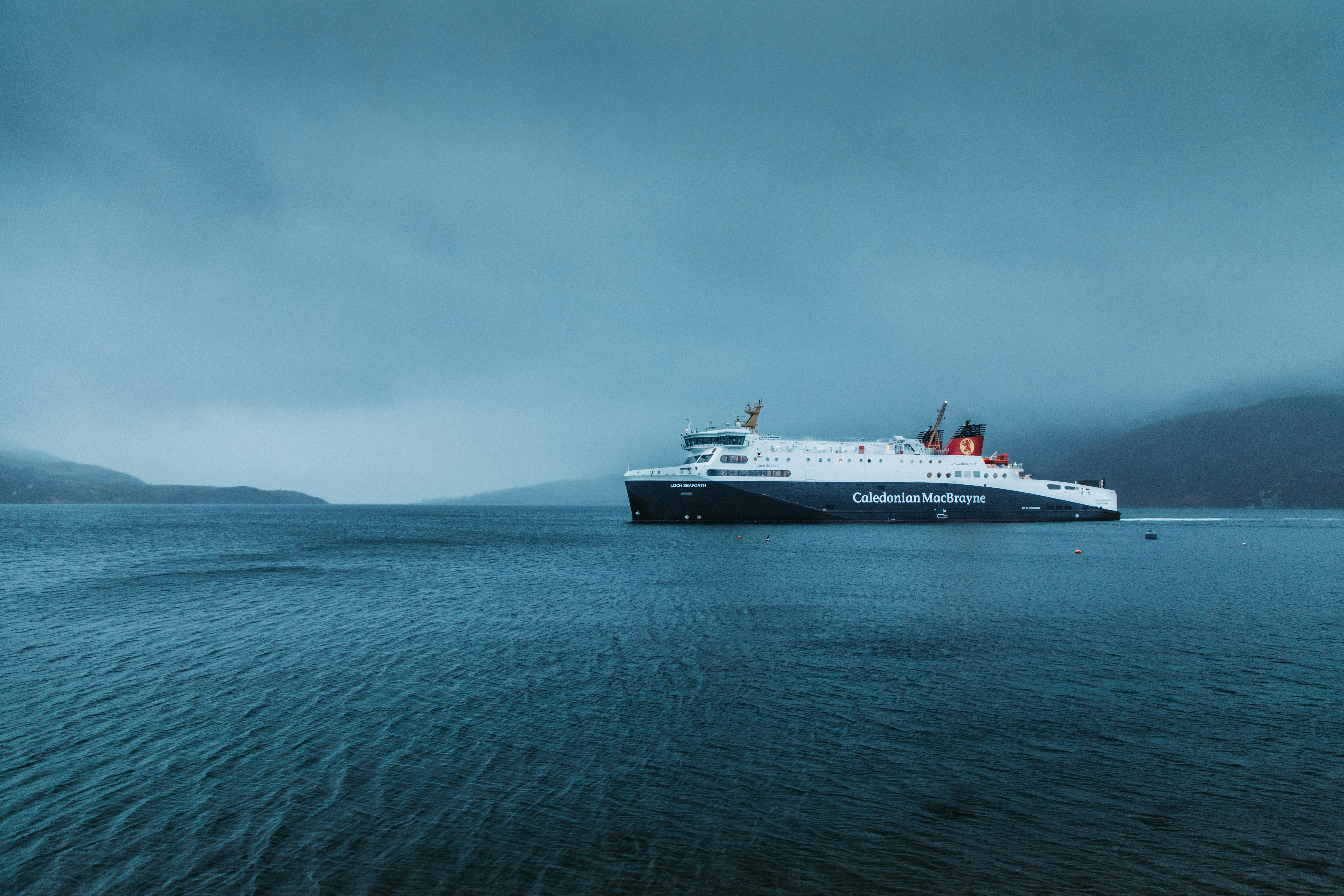 white and black ship surrounded by body of water